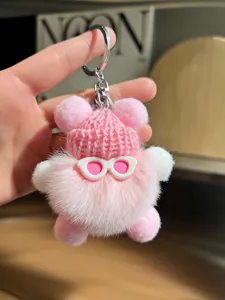 Vue détaillée d'un porte-clés en peluche rose avec bonnet tricoté et lunettes roses