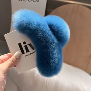 Macro shot of fluffy bright blue faux rabbit fur hair claw clip with plush texture