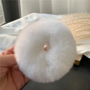 Close-up of a white fluffy rabbit fur scrunchie showing soft texture and plush detail