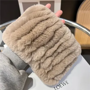 Detailopname van de pluche imitatiebont sjaal in lichtkoffie met golfachtige textuur