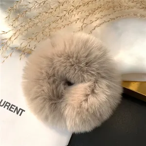 Detail of plush faux rabbit fur scrunchie in beige showing soft texture and fluffy fibers