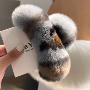 Detailed close-up of a large fluffy faux fur hair claw clip in grey and brown tones