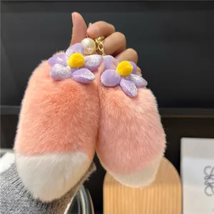 Detailed shot of soft plush fox tail keychain with golden chain and large pearl accent