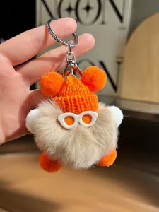 Gros plan d'un charme peluche mignon avec bonnet orange tricoté et anneau argenté
