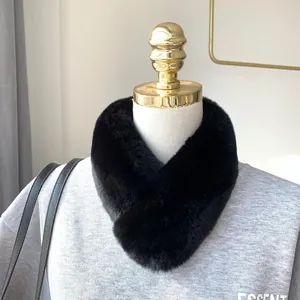 Detail of a thick black faux fur scarf featuring a cross-loop design and soft texture