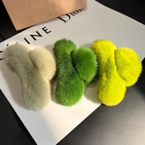 Macro detail of plush rabbit fur hair claws in three shades of green for winter hair styling