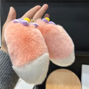 Pink and white plush rabbit tail keychains with purple flower decor and gold ring
