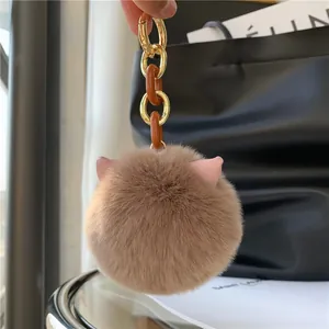 Close-up of soft faux fur cat ear keychain with elegant gold and resin links detail