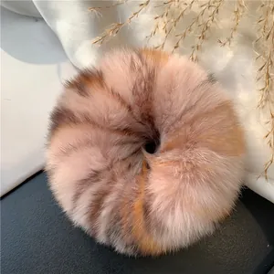 Macro detail of plush faux rabbit fur scrunchie in tricolor pink brown and orange