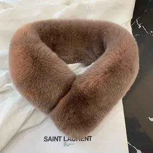 Close-up of fluffy faux rabbit fur scarf in brown on a marble surface with magazine