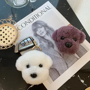 Cute teddy dog plush keychain charms in white and purple wool fur with golden ring detail
