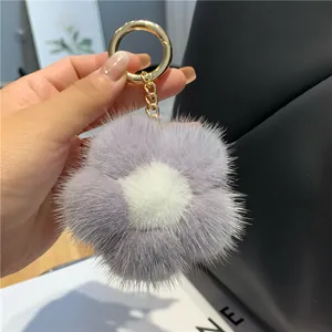 Vue détaillée d'un porte-clés fleur en fourrure douce avec anneau en métal doré chic