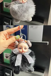 Detail of cute doll faux fur pompom keychain with silver ribbon and metal lobster clasp
