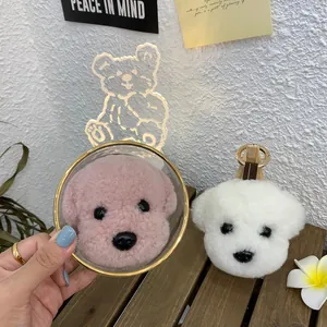 Detail of plush poodle keychain with curly wool fabric and golden metal ring