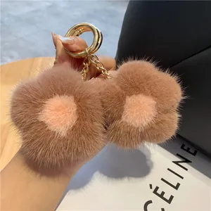 Détail du porte-clés fleur en peluche avec texture vison et anneau en métal doré