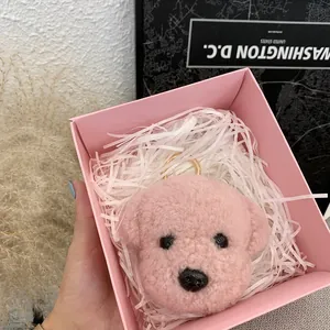 Pink curly plush teddy dog keychain charm in a gift box with white filler and gold ring