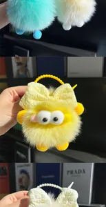 Pluche gele roetgeest sleutelhanger met strik en grote witte ogen voor rugzak decoratie