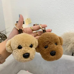 Detail of plush poodle dog charms in beige and brown with golden metal keyrings