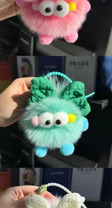 Detail van zachte imitatiebont monster sleutelhanger met grote ogen en kralenketting
