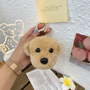 Detailed macro of a cute plush teddy dog keychain with a gold ring and brown strap
