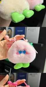 Detail of pink plush peach keychain with blue eyes and 'Princess' acrylic tag charm