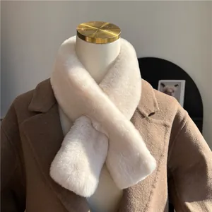 Dettaglio della sciarpa in finta pelliccia beige con texture morbida e chiusura a incrocio