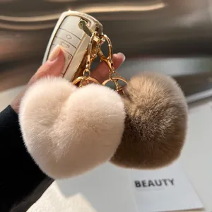 Detail van zachte hartvormige bontsleutelhangers in beige en bruin met gouden haken