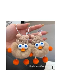 Detail of cute brown plush bird charms with knitted hats and elastic hanging ropes