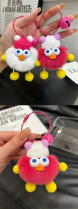 Detail of plush duck charms with knitted hats, big eyes, and colorful metal bells
