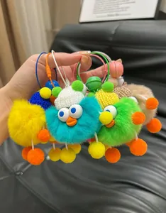 Close-up of fluffy colorful duck plush keychains with knit hats on black background