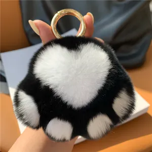 Detailed view of plush cat paw keychain with heart-shaped pad and gold spring ring