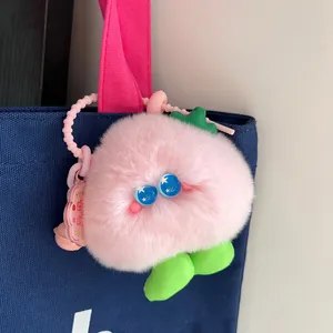 Cute pink plush rabbit fur peach keychain with star eyes on blue canvas bag