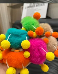 Close-up of colorful faux rabbit fur charms in orange, pink, blue, and green colors