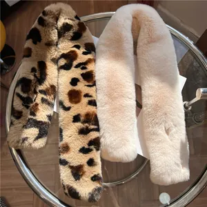 Dettaglio di sciarpe soffici in ecopelliccia con stampa leopardata e bianco crema