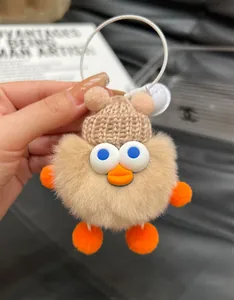 Detailed macro shot of a plush duck keychain with fluffy faux fur and knit hat