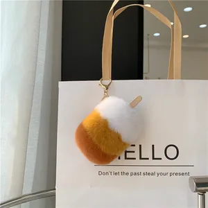 Makro-Detail von Plüsch-Eis-Anhänger mit Metallverschluss an einer weißen Handtasche