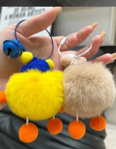 Detail of plush duck keychains in yellow and beige with knit hats and jingling bells