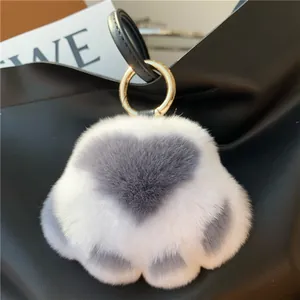 Close-up of fluffy white faux fur heart charm with grey center on a black handbag