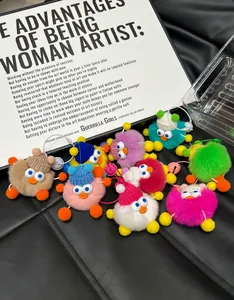 Macro detail of colorful faux fur duck charms with knit hats and big eyes on black leather