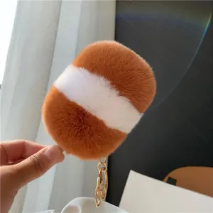 Makroaufnahme der Plüsch-Eiscreme-Schlüsselanhänger aus Webpelz in Orange und Weiß