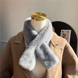 Dettaglio di una morbida sciarpa in finta pelliccia grigia abbinata a un cappotto beige