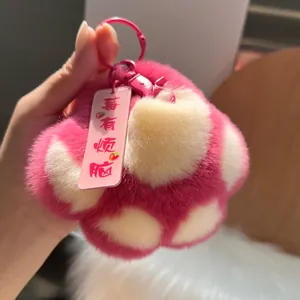 Nahaufnahme von flauschigem Plüsch-Katzenpfoten-Anhänger in Rosa und Weiß mit Anhänger