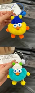 Detail of plush yellow duck keychain with knit hat and colorful metal bell ring