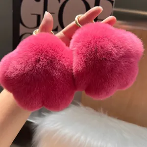 Nahaufnahme von flauschigen rosa Katzenpfoten-Schlüsselanhängern mit Goldring