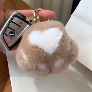 Plush cat paw keychain in brown and white fur with gold ring and heart pattern