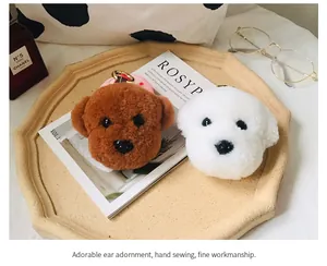 Dettaglio di portachiavi in peluche Bichon e Teddy con fibbie in metallo dorato e nastri
