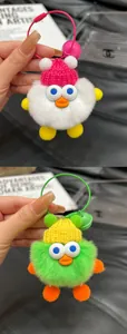 Detailed plush ball monster keychain with soft faux fur, knit hat and gold metal ring