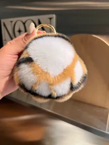 Close-up of tricolor plush cat paw keychain with soft fur and golden metal ring hook