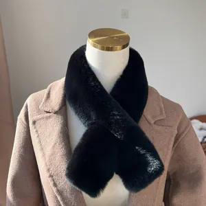 Dettaglio sciarpa in pelliccia di coniglio nera abbinata a un cappotto di lana marrone