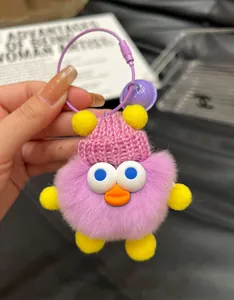 Close-up of purple plush duck keychain featuring a pink knit hat and metal ring